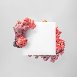 Paper card note on pastel gray background with coral cloud shapes