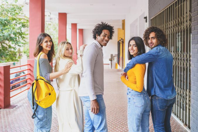 Multi-ethnic group of students turning around looking at camera and smiling