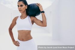 Athletic woman doing fitness workout holding a medicine ball on her shoulder 0y6yn5