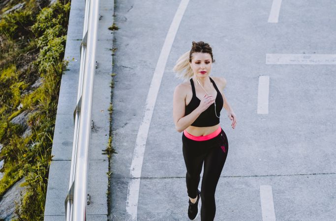Woman running on embankment near water