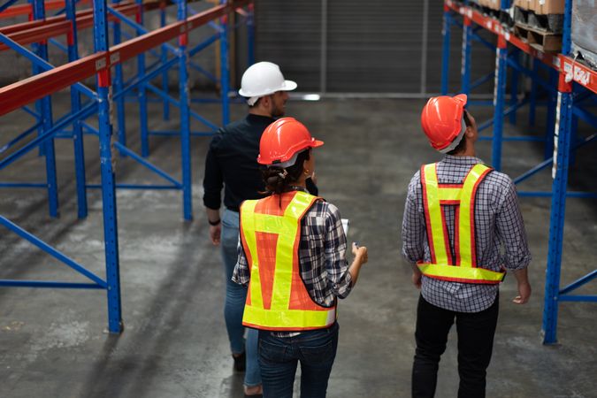 Team of warehouse workers inspecting inventory in a logistics facility.