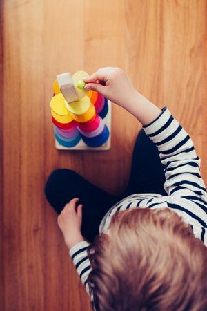 Boy playing with wooden construction pieces