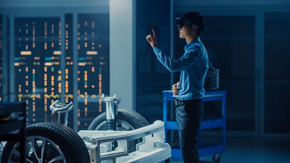 Automotive Engineer Working on Electric Car Chassis Platform, Using Augmented Reality Headset with Touching Gestures.