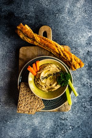 Traditional hummus spread with breadsticks and crackers to dip