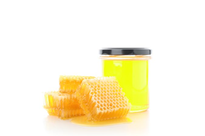 Pieces of honeycomb and glass jar with honey isolated on blank background