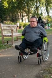 Man in wheelchair going through park 0LeBD5