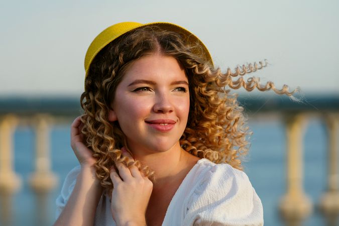 Portrait happy female in yellow hat outdoors