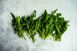 Arugula leaves scattered on grey counter