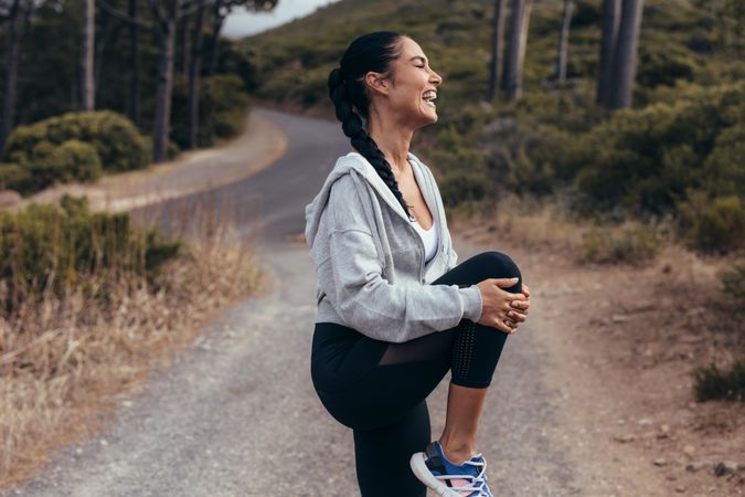 Fitness woman stretching her leg before a run