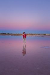 Woman taking picture with camera on empty beach