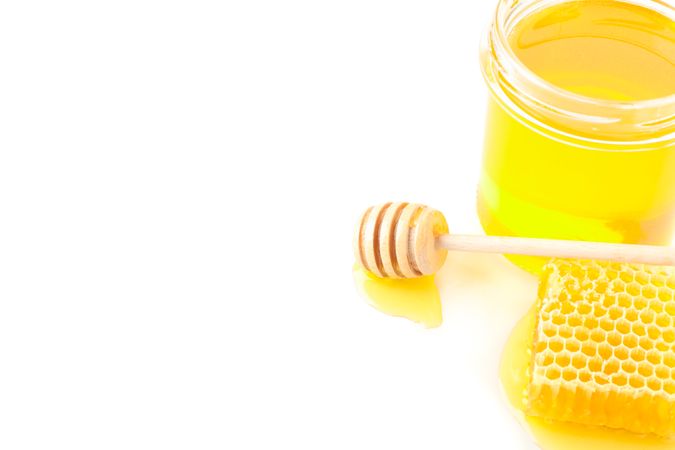 Glass jar, honeycomb and dipper isolated on neutral background