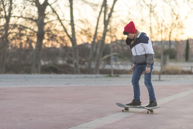 Young man riding on skateboard outside