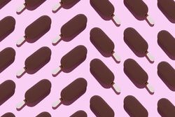 Chocolate popsicles on pink background