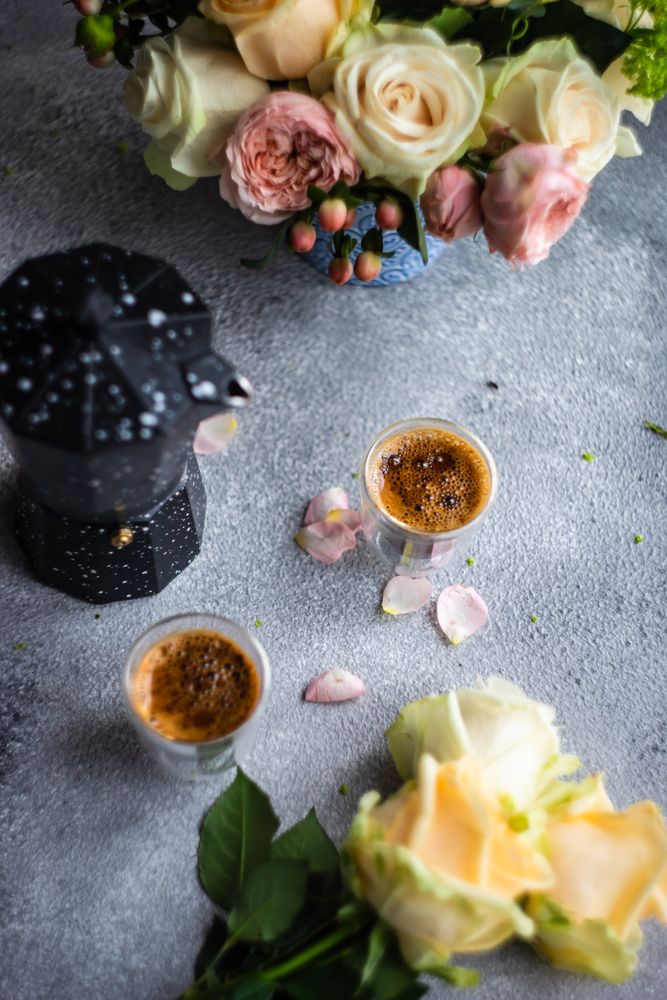 Top view of floral card on concrete background with two espressos