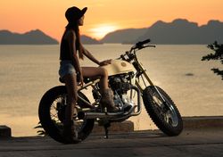 Woman with motorbike near sea