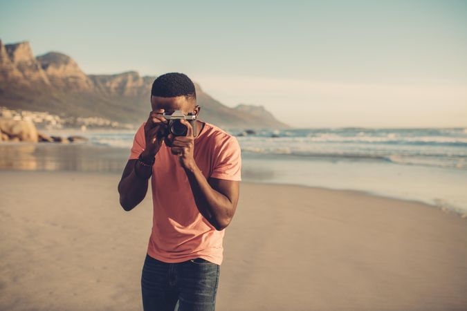 Man taking photos with digital camera on the beach