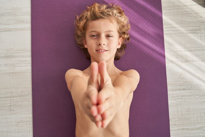 Content child with raised arms during yoga training