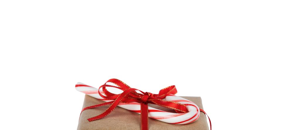 Top of Christmas brown gift box and candy cane isolated on plain background with plenty of copy space
