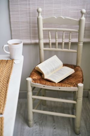 Chair with book near table with tea