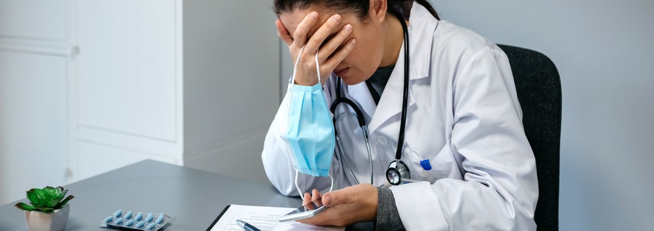 Worried female doctor with hands on face
