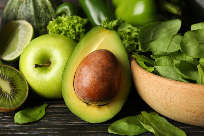 Green vegetables and fruits on wooden background