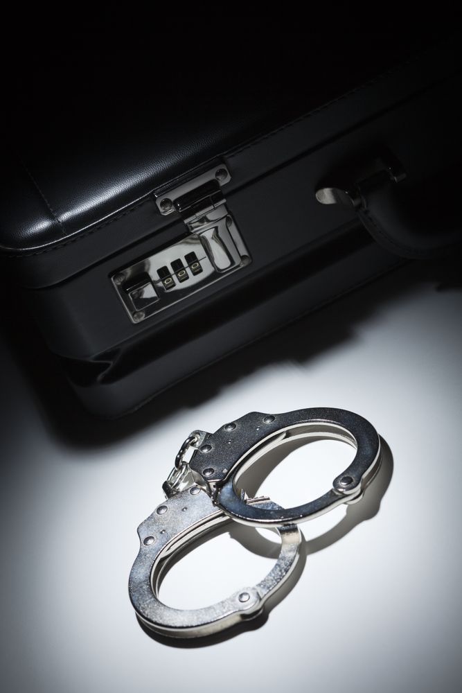 Pair of Handcuffs and Briefcase Under Spot Light