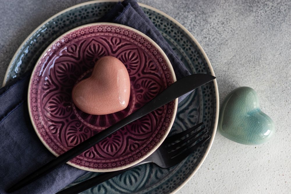 Ornate plates with pastel ceramic hearts on concrete counter