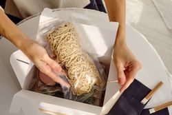 Woman unpacking with box for traditional Japanese meal