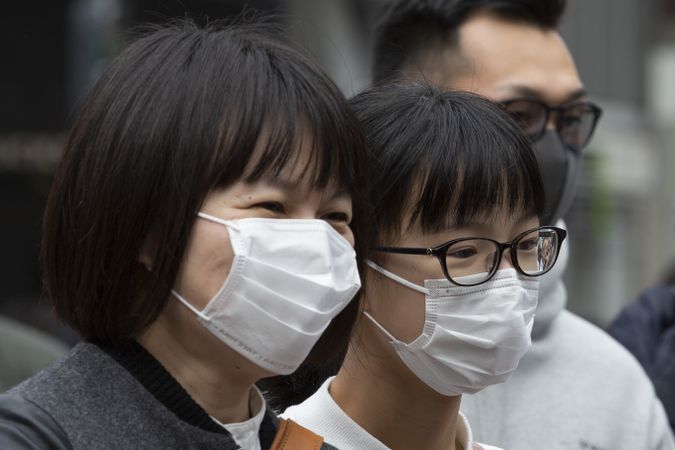 People with facemasks standing outdoor