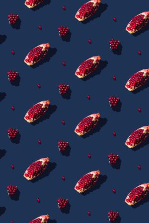 Pattern of pomegranate fruit slices on navy background