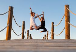 Women posing in air on footbridge