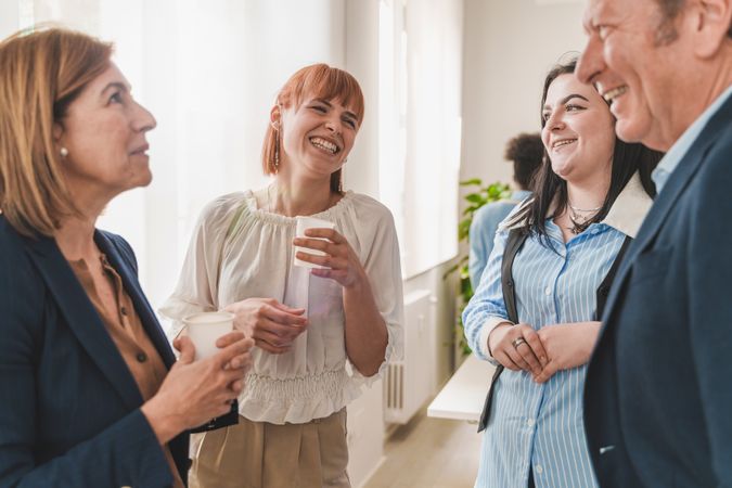In an office a group of colleagues enjoy a light-hearted break
