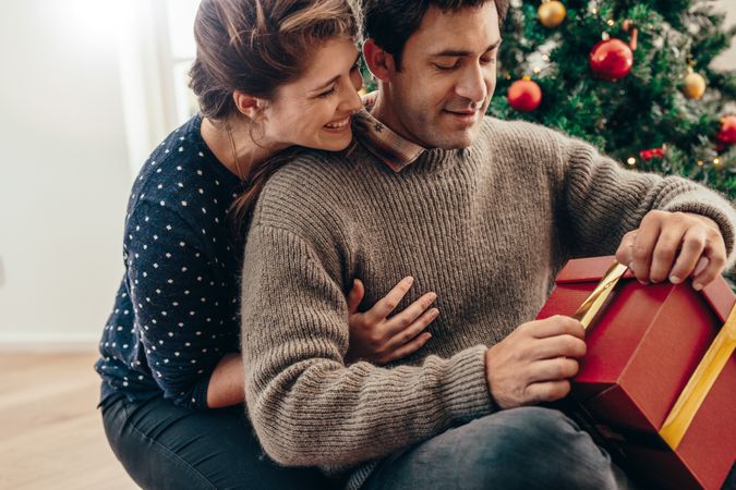 Young couple having fun celebrating Christmas with gifts