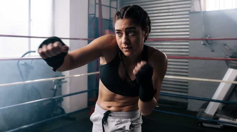 Female boxer training boxing in ring