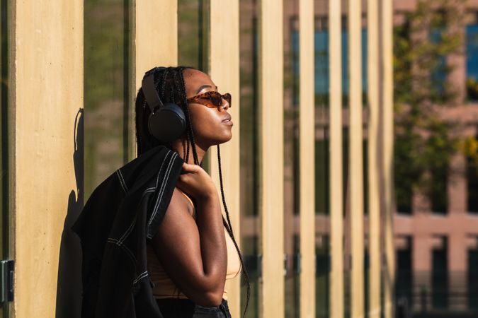 female listening to music outside modern building