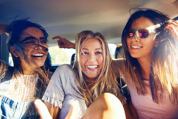 Group of female friends happy while riding in back of car