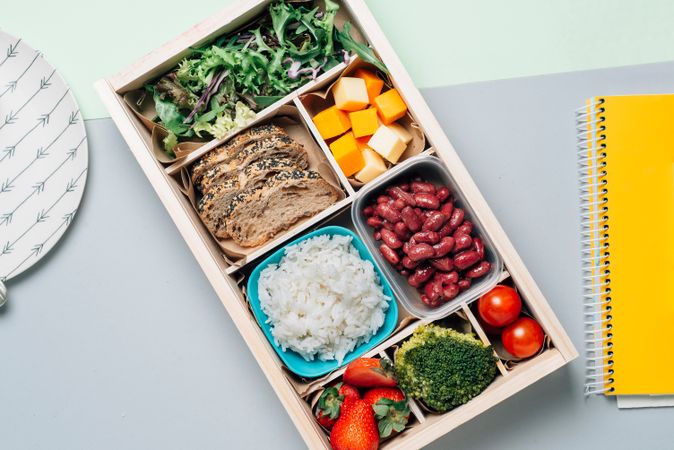 Food box with diet ingredients by copybook and plate