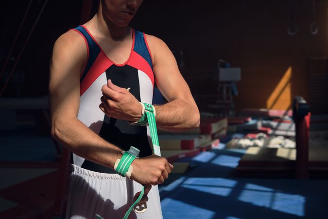 Unrecognizable person putting on wristbands to perform gymnastic exercises.