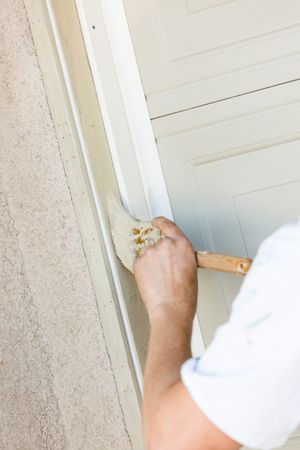 Professional Painter Cutting In With Brush to Paint Garage Door Frame