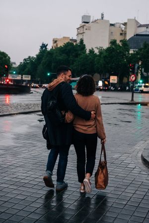 Young couple walking on wet street