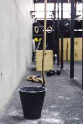 Rope near bucket of chalk in gym