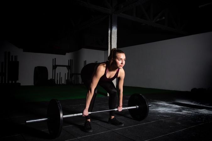 Woman lifting barbell in gym