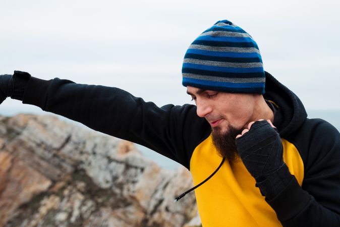 Kickboxer training on cliff near sea