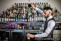 Bartender pouring a cocktail into shaker 5rKDl4
