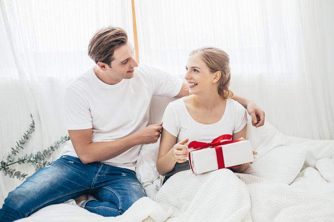 Happy woman receiving present from partner at home