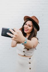 Woman smiling and taking selfie on smartphone