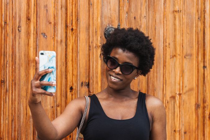 Young Black woman taking selfie on smartphone