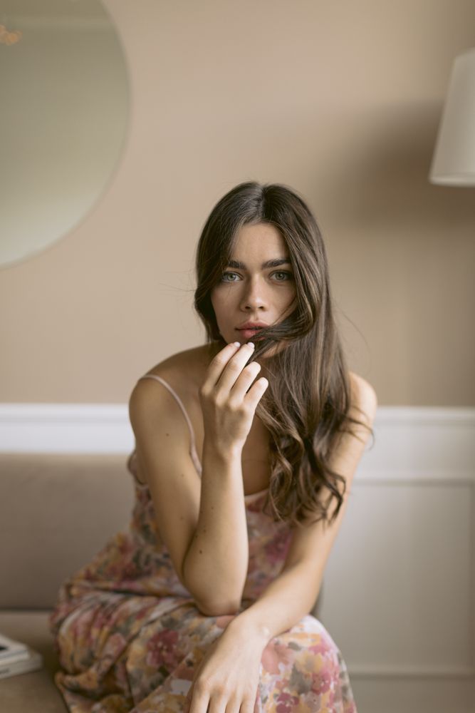 Young woman sitting touching her hair
