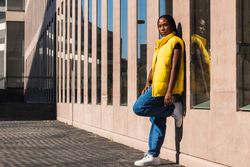 Trendy woman leaning on building wall