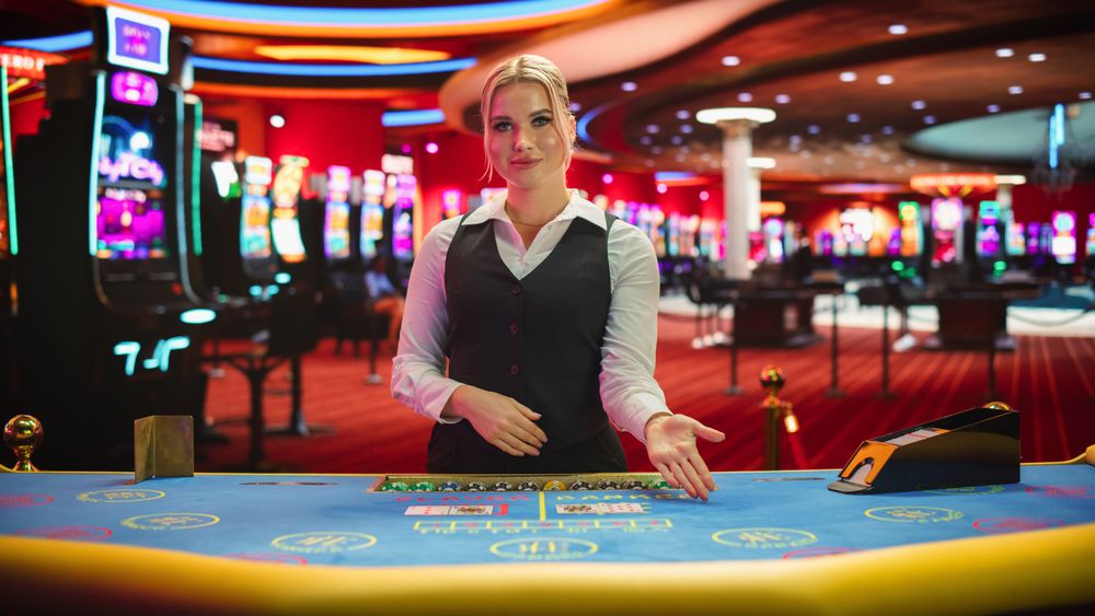 Professional Female Croupier in Casino Dealing Playing Cards on a Baccarat Table.